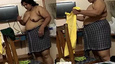 Fat Indian woman with big belly walks around the house with naked boobs